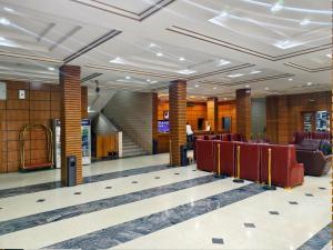 a lobby of a building with red chairs and stairs at Jun Yue 9 Hotel Kano in Kano