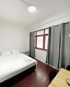 un dormitorio con una cama y una ventana en GO INN Siriraj Wang Lang - โก อินน์ ศิริราช ตลาดวังหลัง Pro, en Bangkok Noi