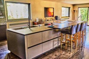 PalazzoneにあるGodiluvaのバースツール付きの大きな島のあるキッチンが備わります。