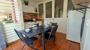 a kitchen with a table with chairs and a stove at Ti Mabouya Appartement Saint François in Saint-François