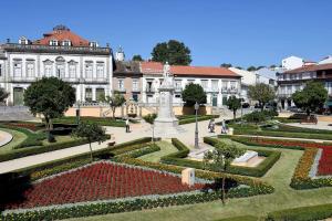 a park with a fountain in front of a building at Bracara Guest House "Campo Novo" in Braga