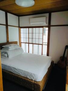 a bedroom with a bed and a guitar in a room at Nara House R2 in Kawagoe
