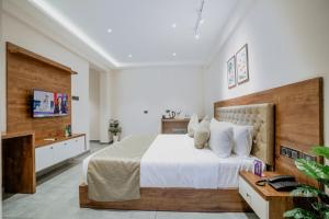 a bedroom with a large bed and a television at Seaking Suites in Ernakulam +36 photos
