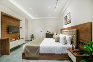 a bedroom with a large bed and a television at Seaking Suites in Ernakulam