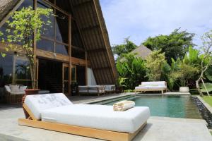 a swimming pool next to a villa at The Sawah Lodge, Seseh-Bali in Seseh