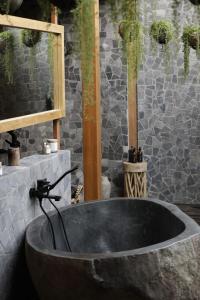 a large black tub in a bathroom with a wall at The Sawah Lodge, Seseh-Bali in Seseh +9 photos