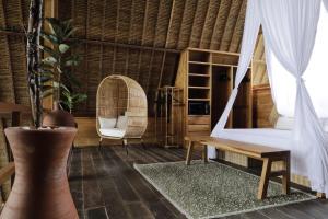 a room with a hammock and a table and a chair at The Sawah Lodge, Seseh-Bali in Seseh