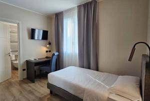 a bedroom with a bed and a desk and a window at Hotel Ristorante al Giardinetto in Colle Umberto +43 photos