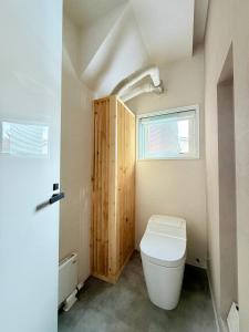 a bathroom with a toilet and a window at The Lobs 4, 6BR 4BATH 8 mins to Rusutsu Brand new 2025 in Kimobetsu
