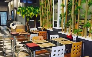 a restaurant with tables and chairs and plants at The Grace Residence in Surin