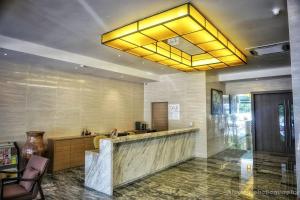 a lobby with a bar with a yellow ceiling at Nex Hotel Johor Bahru in Johor Bahru