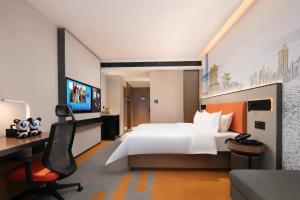 a hotel room with a bed and a desk and a computer at Hilton Garden Inn Nanchang Chaoyang Center in Nanchang