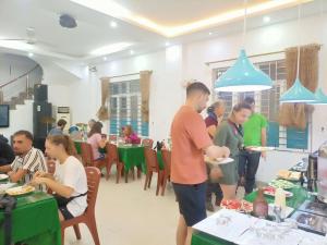 a group of people standing in a room with plates of food at catba island hotel in Cat Ba