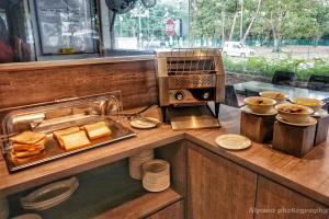 a counter with bread and a plate of food at Nex Hotel Johor Bahru in Johor Bahru