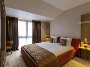 a hotel room with a large bed and a window at Movenpick Resort and Spa Fruske Terme in Vrdnik +131 photos