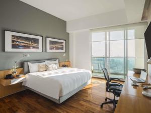 ein Schlafzimmer mit einem Bett und einem Schreibtisch mit Stuhl in der Unterkunft The Paragon Hotel Mexico Santa Fe By Accor in Mexiko-Stadt