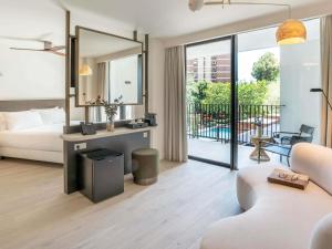 a living room with a bed and a mirror at Mercure Benidorm in Benidorm