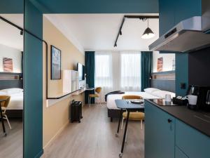 Habitación de hotel con cama, cocina y habitación en Adagio Access Gent Centrum Dampoort, en Gante