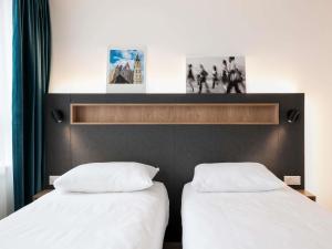 Dos camas una al lado de la otra en una habitación. en Adagio Access Gent Centrum Dampoort, en Gante 77 fotos más