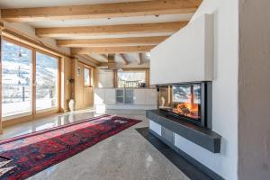 ein Wohnzimmer mit einem Kamin und einem großen Fenster in der Unterkunft Logenplatz Zillertal in Ramsau im Zillertal