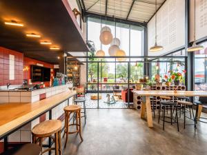 ein Restaurant mit einer Theke, Stühlen und Tischen in der Unterkunft Greet hotel Bourg-en-Bresse Sud Montagnat in Montagnat