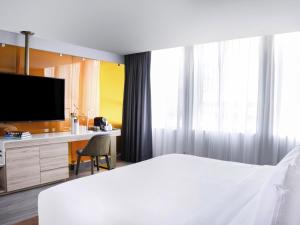 een slaapkamer met een bed en een bureau met een televisie bij Mondrian Mexico City Condesa in Mexico-Stad +127 foto's