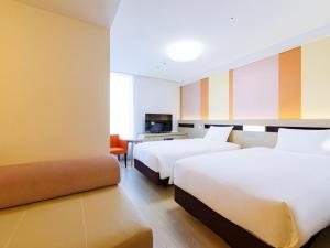 ein Hotelzimmer mit zwei Betten und einer Couch in der Unterkunft Hotel Dream Gate Maihama Annex in Chiba + 201 Fotos
