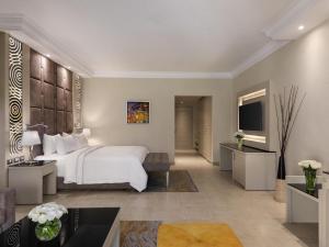 a hotel room with a bed and a television at Rixos Sharm El Sheikh - Adults Only 18 Plus in Sharm El Sheikh