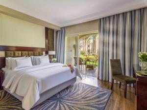 a bedroom with a large white bed and a dining room at Rixos Sharm El Sheikh - Adults Only 18 Plus in Sharm El Sheikh