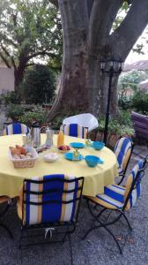 una mesa amarilla con sillas bajo un árbol en Berne &Michel en Montfavet