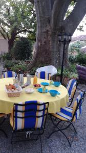 蒙法維的住宿－伯爾尼與米歇爾住宿加早餐旅館，树下一张带椅子的黄色桌子