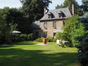 a large wooden house with a picnic table in a yard at La Maison De Lalette in Gruchet-Saint-Siméon