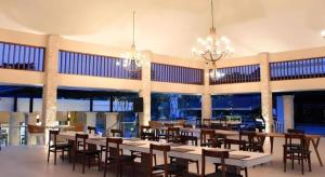 een eetkamer met tafels, stoelen en kroonluchters bij Putri Duyung Ancol in Jakarta