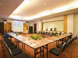 a large meeting room with a long table and chairs at Grand Surya Hotel Kediri in Kediri +195 photos