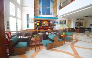 a lobby with a bar and chairs in a building at Grand Surya Hotel Kediri in Kediri