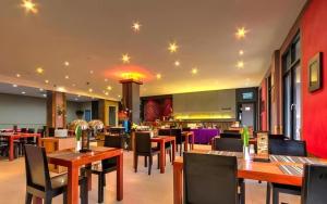 een restaurant met houten tafels en stoelen in een gebouw bij Plan B Hotel in Kampungdurian