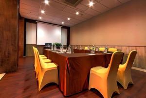 een vergaderzaal met een lange tafel en gele stoelen bij Plan B Hotel in Kampungdurian