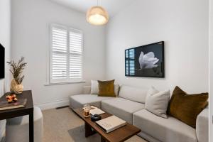 a living room with a couch and a table at Luxury Ponsonby Villa in Auckland