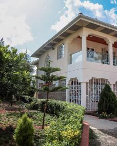 Stylish 3-BR Apt in Chuna, Kitengela في Athi River: منزل أمامه شجرة