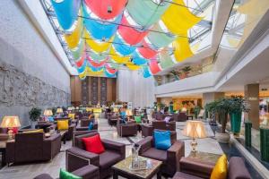 a lobby with chairs and tables and colorful umbrellas at Kunming Jinjiang Hotel in Kunming