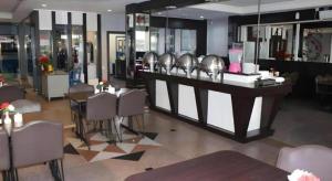 a restaurant with a bar with tables and chairs at Balai View Hotel in Tanjung Balai Karimun