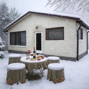 una mesa cubierta de nieve frente a una cabaña en Forest Hide Tiny House, en Covasna