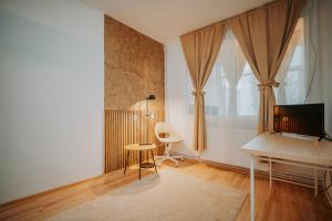 a living room with a table and a desk at Kossuth Apartments in Gheorgheni