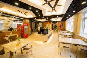 a restaurant with white tables and chairs and windows at Jinjiang Inn Style Shenyang The Palace Huaiyuan Gate in Shenyang