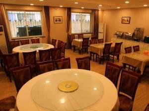 a dining room with tables and chairs and tables and chairsktop at GreenTree Inn Beijing East Yizhuang District Second Kechuang Street Express Hotel in Beijing
