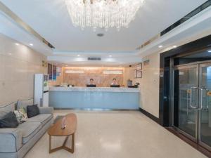 een woonkamer met een bank en een bar bij GreenTree Inn West Railway Station North Square Hotel in Beijing