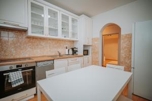 a kitchen with white cabinets and a white counter top at Kossuth Apartments in Gheorgheni