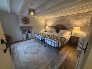 ein Schlafzimmer mit 2 Betten und einer Uhr an der Wand in der Unterkunft Coupling Cottage in Belper