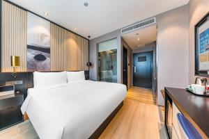 Ένα ή περισσότερα κρεβάτια σε δωμάτιο στο Orange Hotel Beijing Yizhuang Rongjing West Street