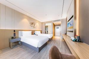 Ένα ή περισσότερα κρεβάτια σε δωμάτιο στο Orange Hotel Beijing Yizhuang Rongjing West Street